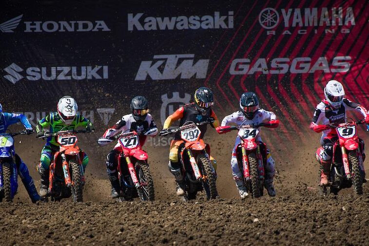 Motocross riders riding out of the starting gate.