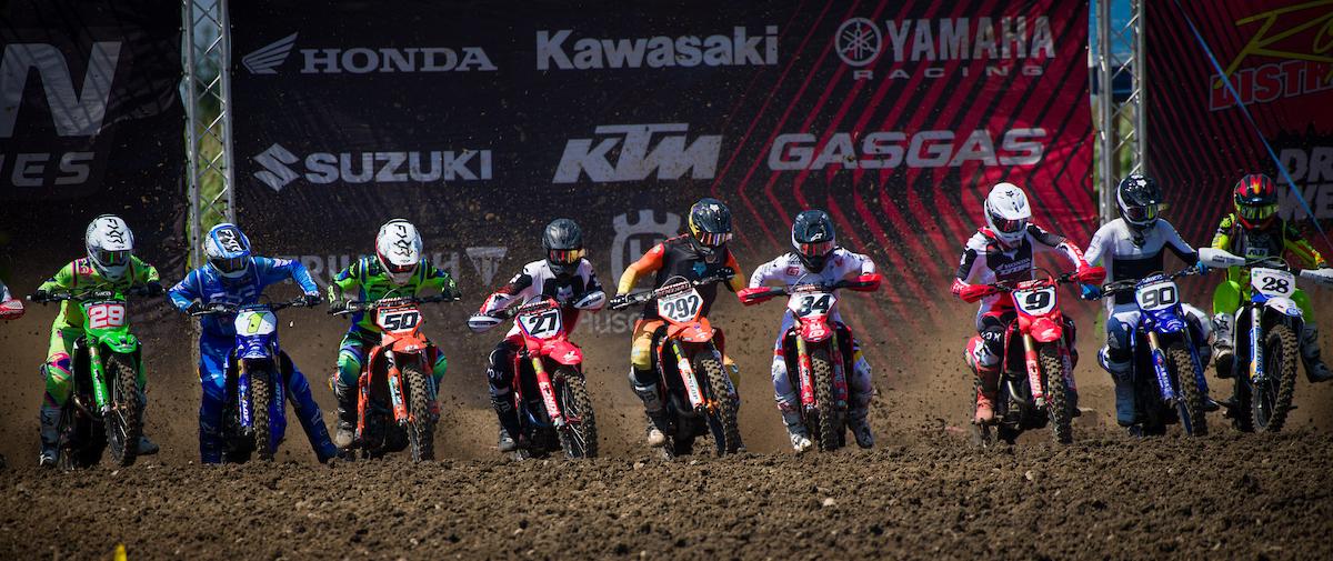 Motocross riders riding out of the starting gate.